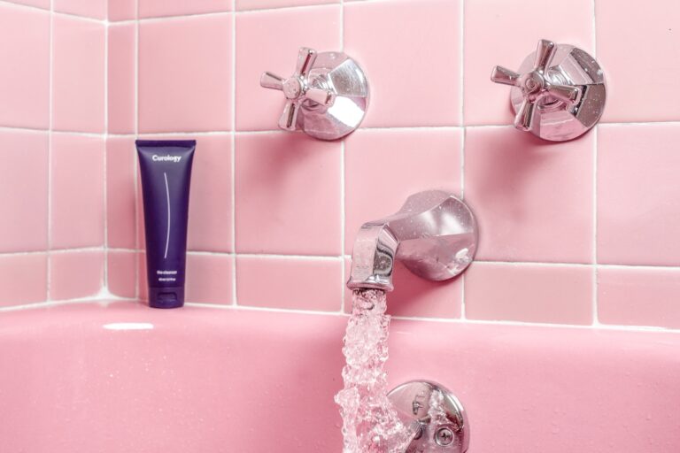 a pink bathtub with a faucet and soap dispenser