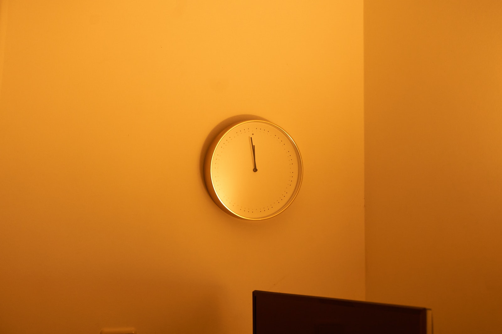 Photo of an Analog Clock on an Orange Wall