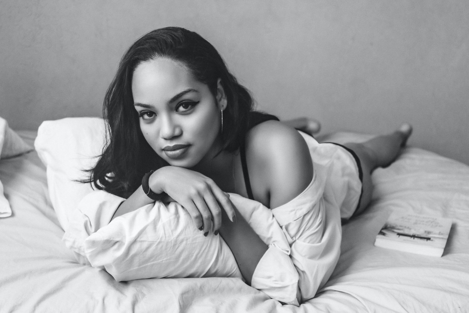 a black and white photo of a woman laying on a bed